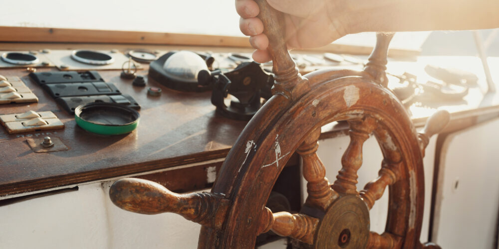 Sun shines over the wooden wheel held by man